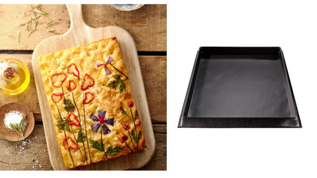 À gauche, une focaccia cuite décorée de légumes et herbes fraîches sur une planche en bois. À droite, un moule en silicone noir vide de forme rectangulaire, prêt à être utilisé pour une nouvelle cuisson.