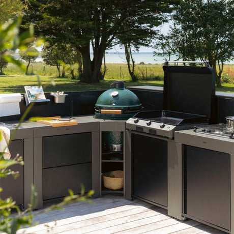  Cuisine extérieure équipée d’un module d’angle ENO pour Kamado, accompagné d’une plancha et d’un meuble de cuisson. Aménagement modulable et fonctionnel pour une cuisine extérieure complète et élégante.
