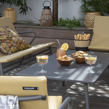 Table basse Vence rectangulaire LAFUMA sur terrasse aménagée avec mobilier CHR, plateau gris titane en acier, ambiance lounge extérieure.